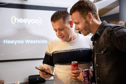 Erik en Tony lachen om iets op een telefoon