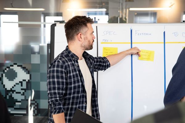 Scrummaster bij het bord met gele briefjes